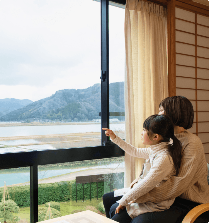 部屋から円山川を見る親子